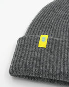 Gray cashmere merino wool beanie with yellow woven label close-up