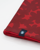 Close-up of a double layer neck warmer with red floral printed lycra,  red fleece lining and black woven CTW logo label