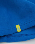 Electric blue polartec fleece short neck warmer with yellow CTW woven logo close-up