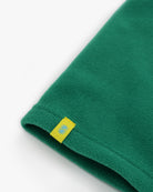 Green polartec fleece short neck warmer with yellow CTW woven logo close-up