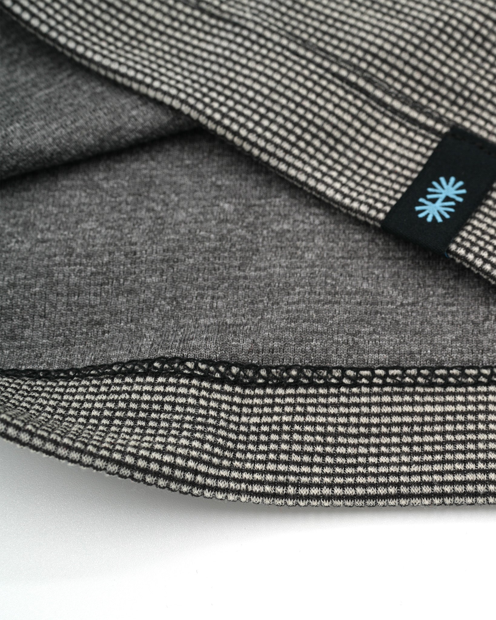 Close-up view of a long gray Power Wool neck gaiter, with a black back seam and black CTW logo woven label