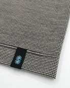 Close-up view of a long gray Power Wool neck gaiter, with a black back seam and black CTW logo woven label