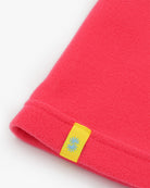 Bright pink polartec fleece short neck warmer with yellow CTW woven logo close-up